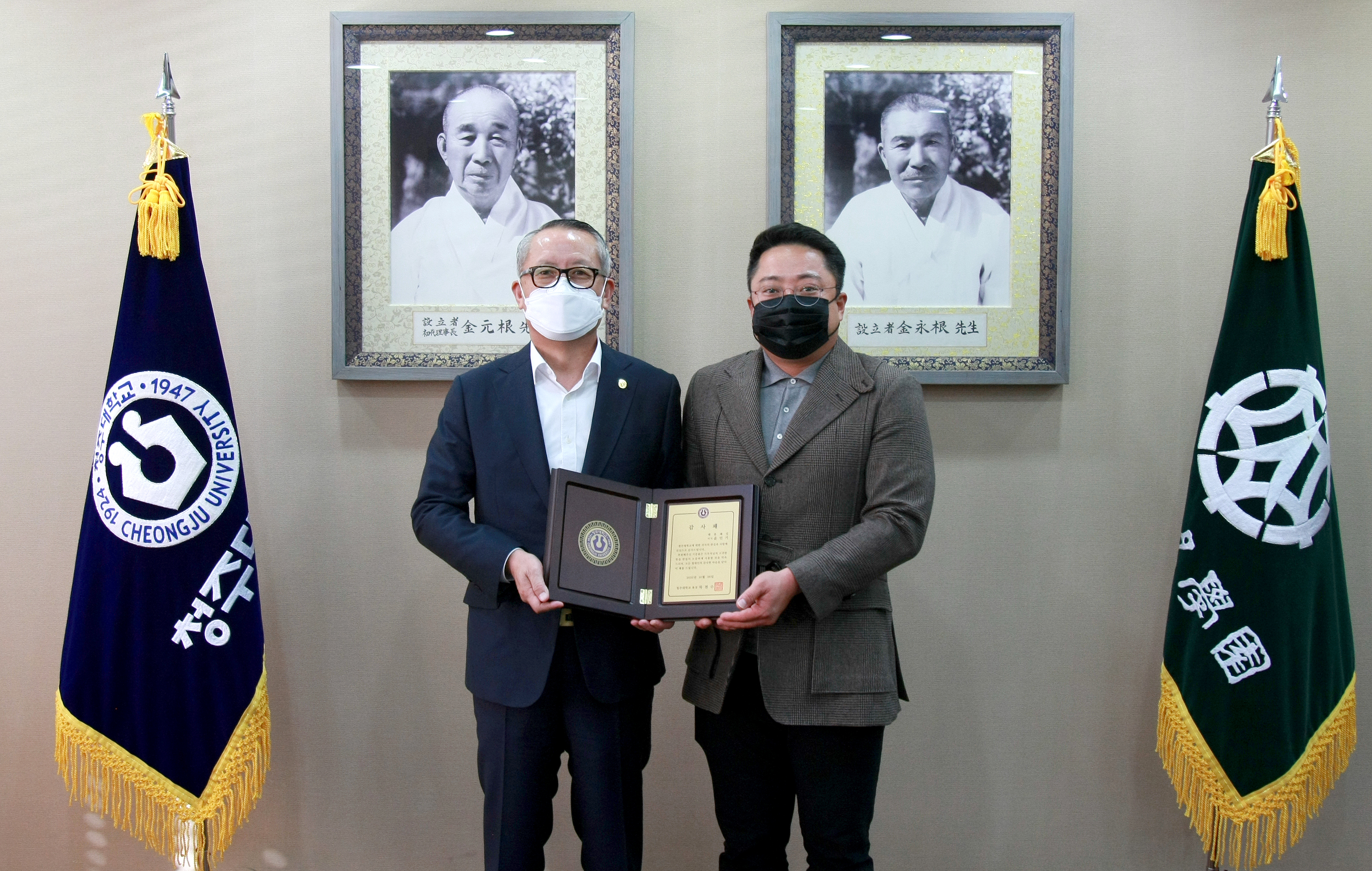 차천수 청주대학교 총장이 KF94 마스크 1만장을 기부한 윤인기 태흥패킹 이사에게 감사패를 전달한 후 기념촬영을 하고 있다.